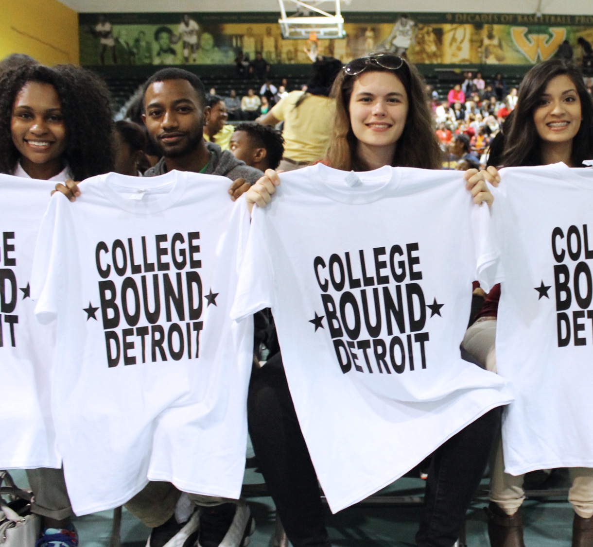 Students holding up College Bound Detroit T-Shirts